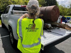 a woman in a safety vest is looking at the back of a truck