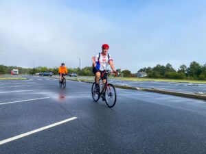 two bicyclists are riding down the road in the rain