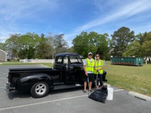 two people standing next to a black truck