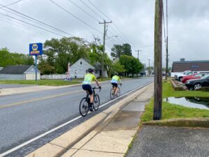 two bicyclists riding down the street in front of a motel