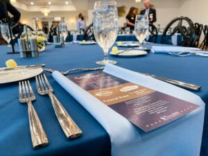 a blue table cloth with silverware and menus on it