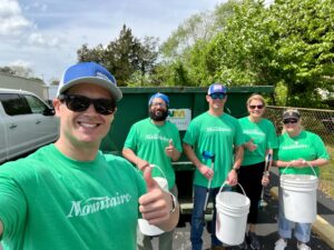 a group of people in green shirts holding buckets