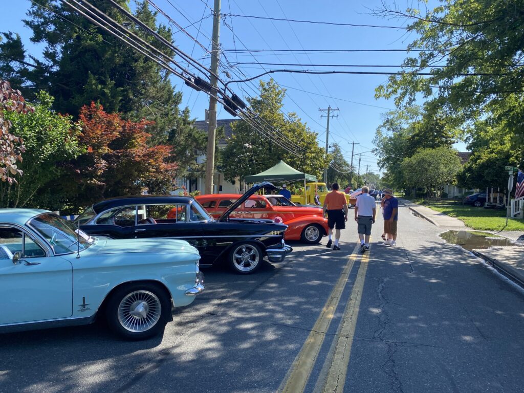 several classic cars parked on the side of the road