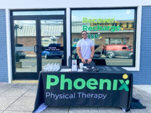 a man standing in front of a table with a phoenix sign on it