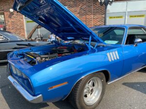 a blue muscle car with its hood open