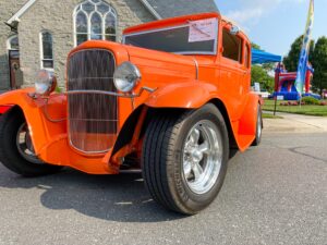 an orange car parked in front of a church
