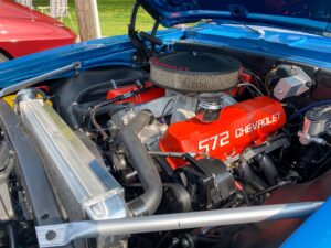 the engine compartment of a blue car with red lettering