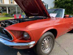an old red mustang with its hood open