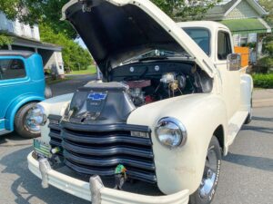 an old white truck with its hood open