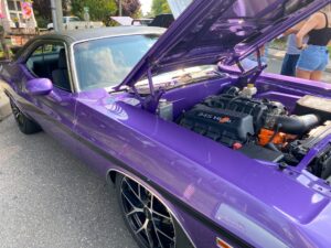 a purple muscle car with its hood open