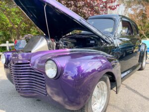 an old purple car with its hood open