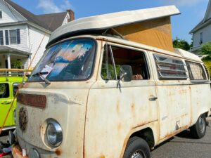 an old vw van with a surfboard on top