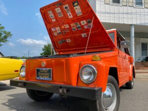an orange truck with its hood open on the street