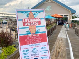 a lifeguard award sign on a wooden boardwalk