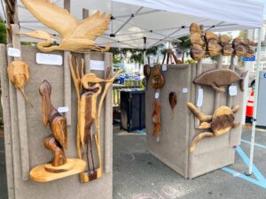 wooden carvings are on display under a tent