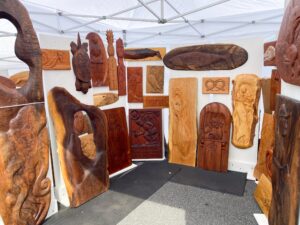 a group of wooden carvings on display under a tent