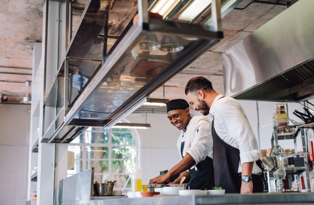 two men are working in a commercial kitchen