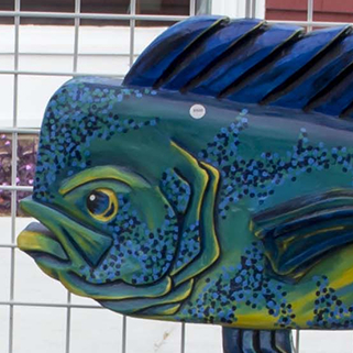a colorful fish statue on display in front of a building