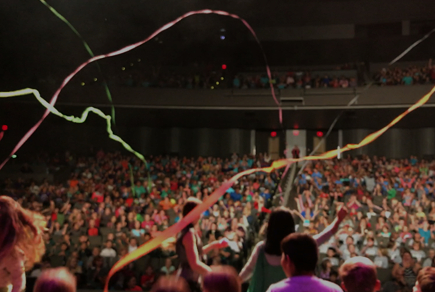 a crowd of people at a concert with streamers in the air