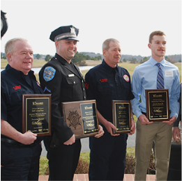 five men in uniform holding plaques and smiling