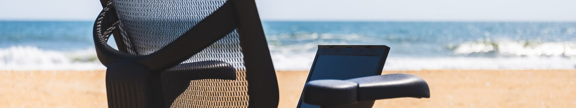 a chair and a cell phone on the beach