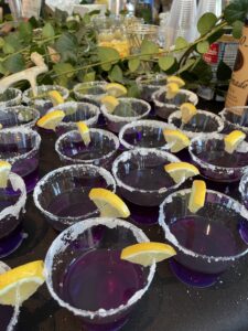 purple glasses with lemon wedges on a table