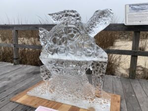 an ice sculpture on a wooden deck near water