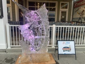 a glass sculpture on a wooden stand in front of a store