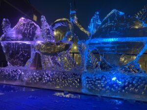 ice sculptures are lit up at night in front of a building