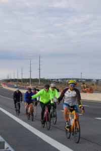 a group of bicyclists riding down the road