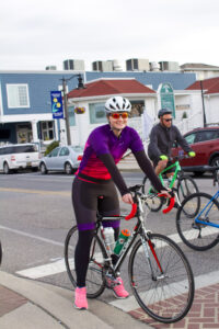 two people riding bikes on a city street