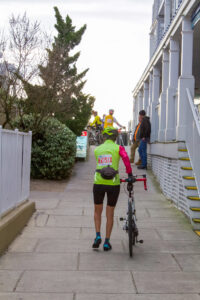 a person in a neon green jacket is walking with a bike