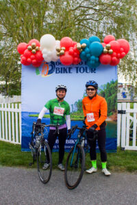 two people standing next to each other with bikes