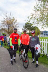 three people standing next to each other on bikes