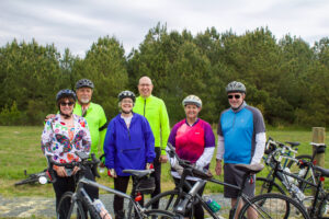 a group of people standing next to each other with bikes