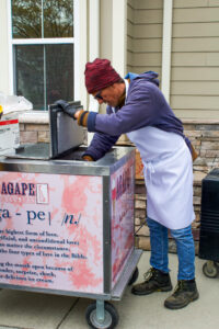 a man in an apron putting food into a cart