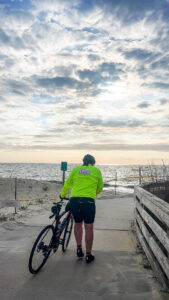 a man in a green jacket is standing with his bike