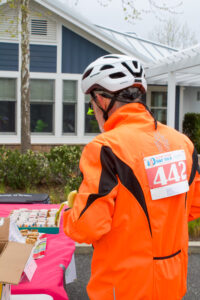 a man in an orange jacket is standing near a table