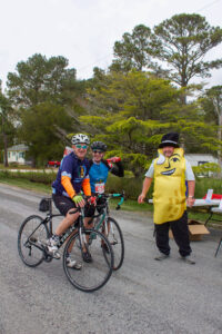 three people in costumes riding bicycles down the street