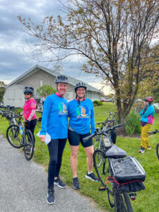 two women standing next to bicycles on a sidewalk