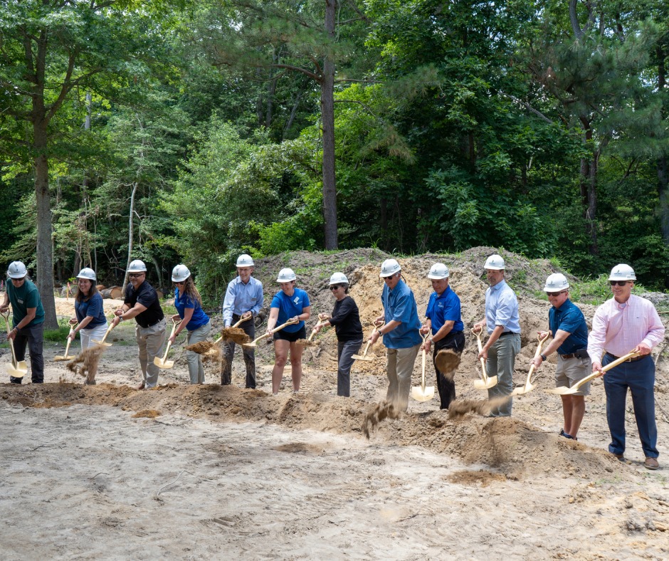 a group of people with shovels standing around a pile of dirt