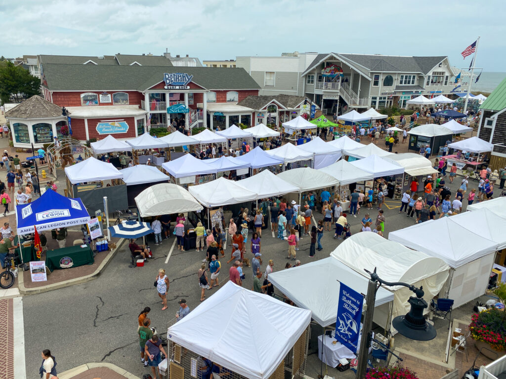 a crowd of people standing around tents on a street