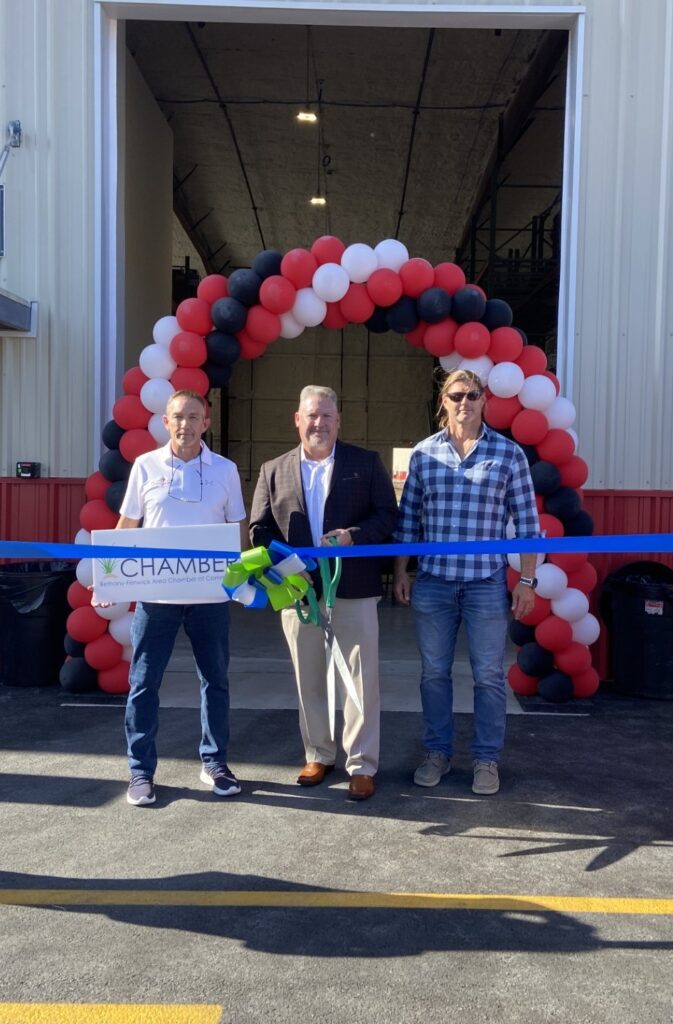 a group of people holding a ribbon in front of a building